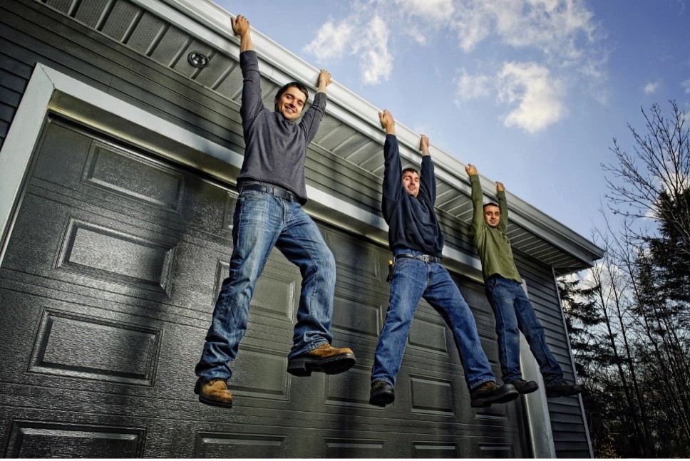 People hanging from gutters with gutter guards