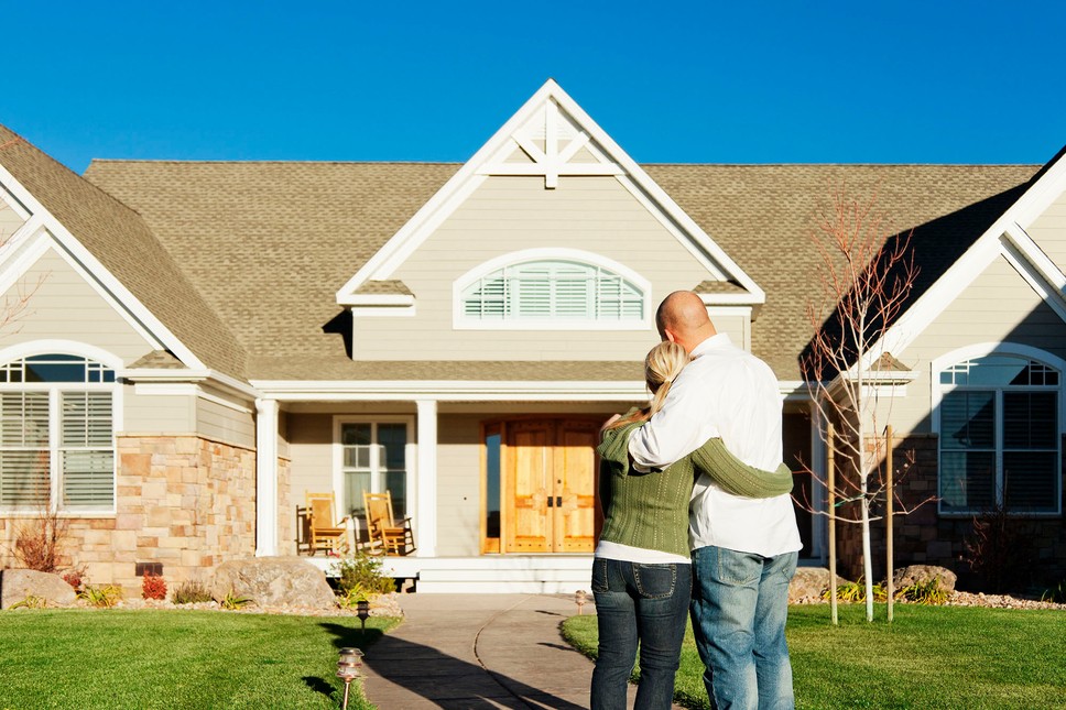 A couple looks at their house after an exterior home remodel.